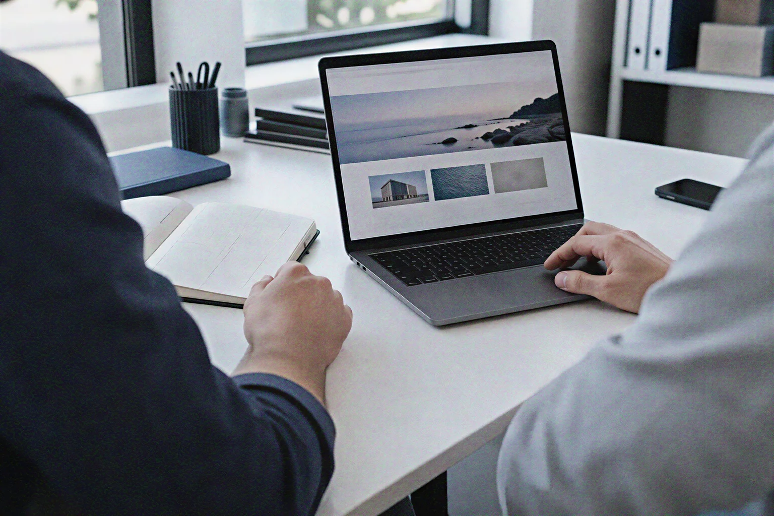KI-Symbolbild: gemeinsame Projektbesprechung mit Laptop und Website-Skizzen